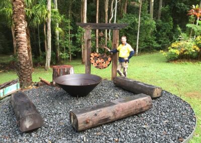 Fire pit, bridge timber seating, recycled timber features and pebble base
