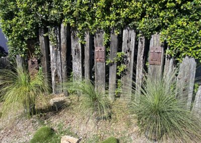 Recycled railway sleepers fence with metal plate features