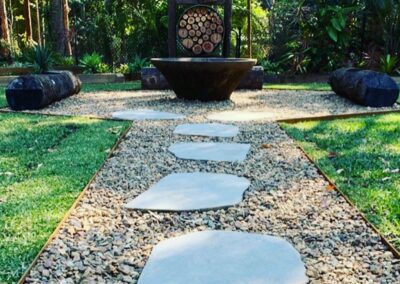 Outdoor entertaining area with fire pit, bridge timbers, recycled timber feature, basalt steppers and sandstone pebbles